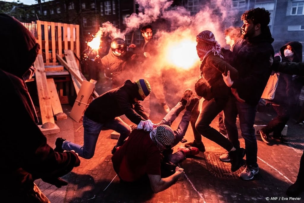 Groep mannen deelt klappen uit aan betogers tentenprotest UvA