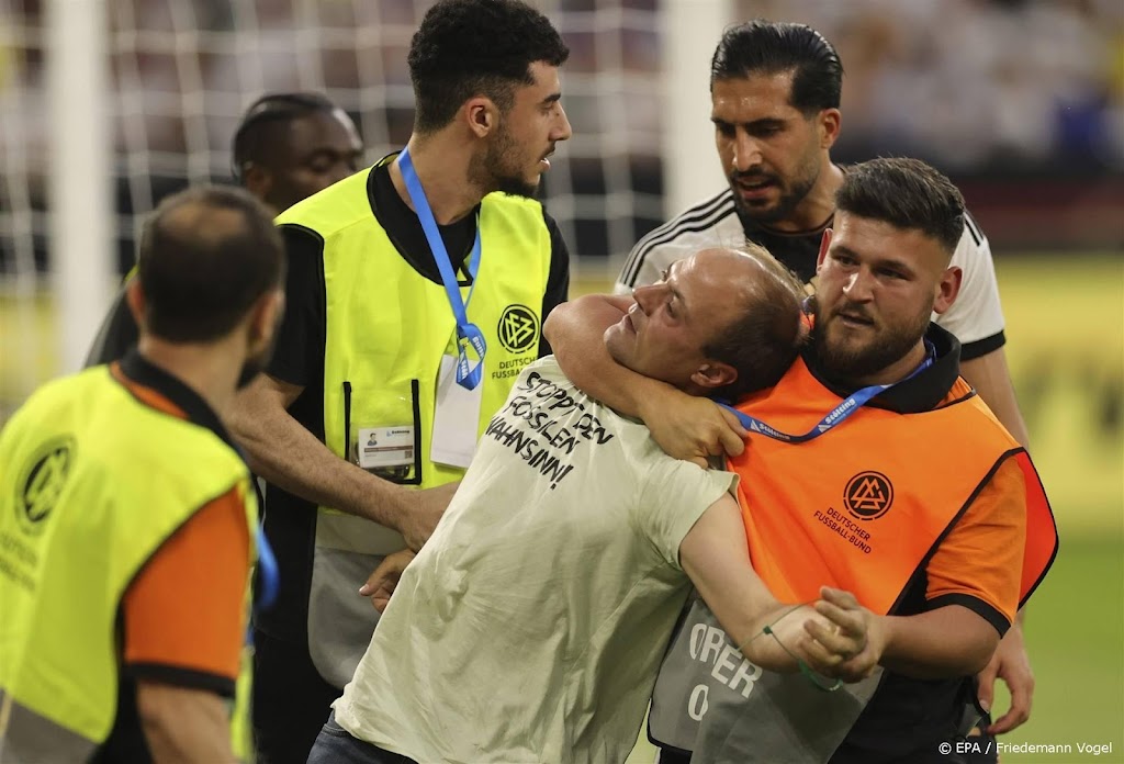 Toeschouwers lopen veld op bij voetbalduel Duits elftal