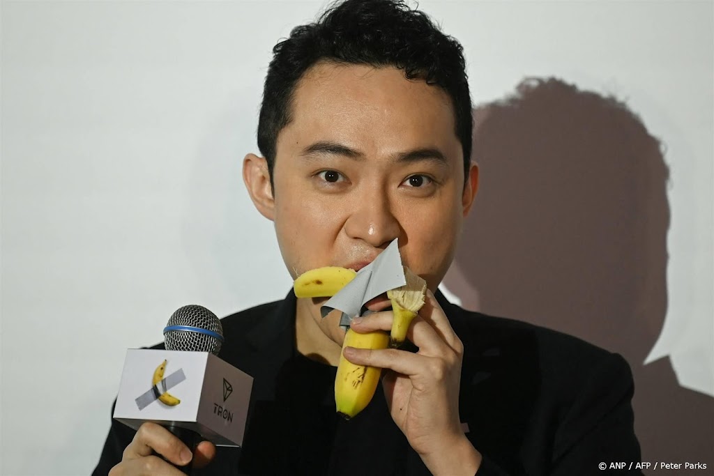 Koper eet banaan op die als kunst aan de muur was geplakt