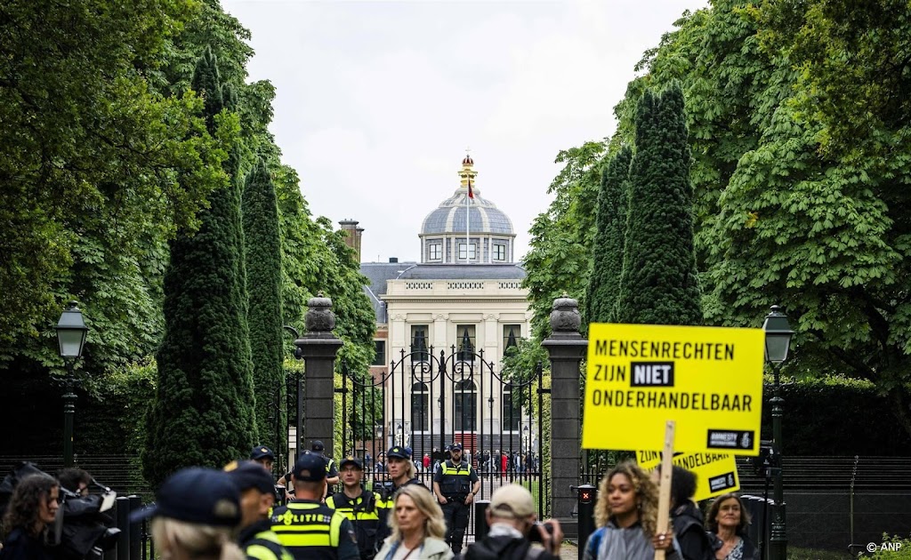 Demonstranten kijken toe bij bordesscène nieuw kabinet met koning