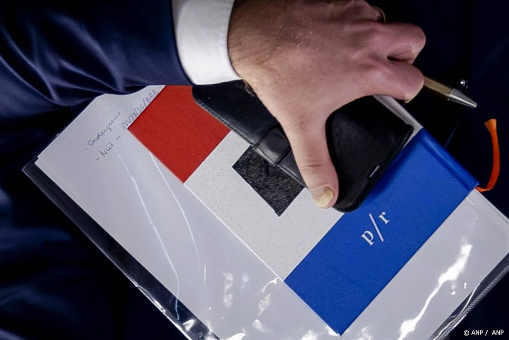 Omtzigt laat zich in de kaart kijken op foto met papier onder arm