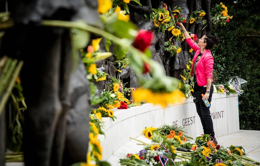 Scholieren leggen zonnebloemen bij Indisch Monument
