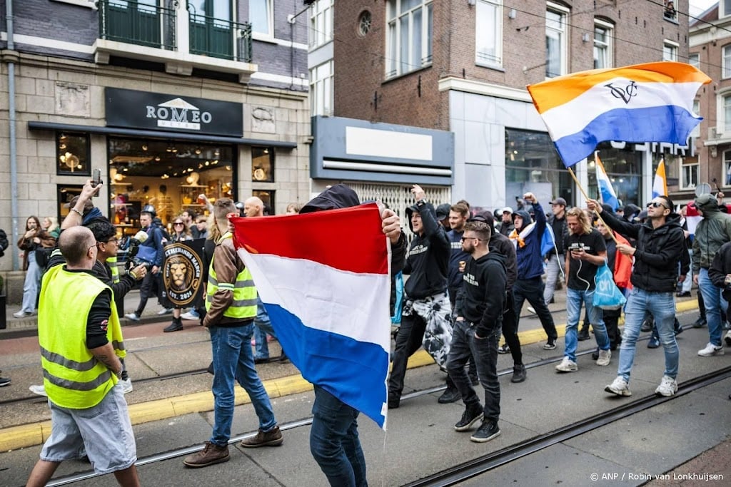 Demonstranten geflankeerd door politie gestart met mars Amsterdam