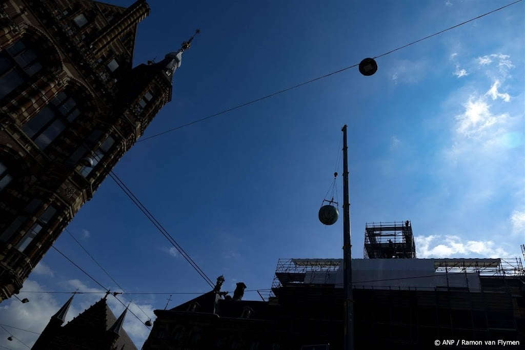 Beeld van Atlas van Paleis op de Dam in Amsterdam gehesen