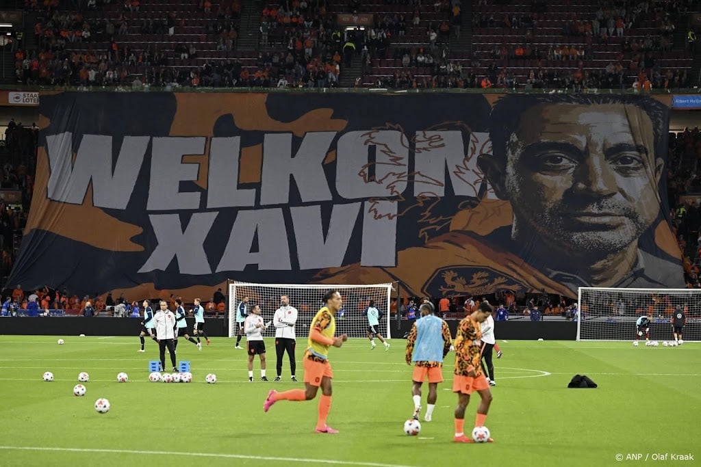 Supporters Oranje ontvangen bondscoach Xavi met groot spandoek