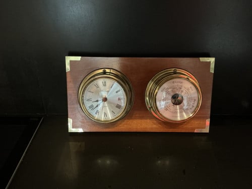 Scheepskok en barometer op houten paneel
