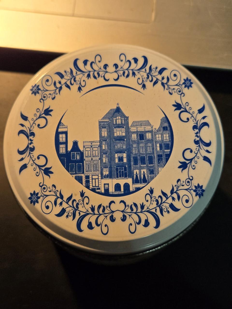 Delfts blauw stroopwafelblik met Amsterdamse grachtenpandjes.