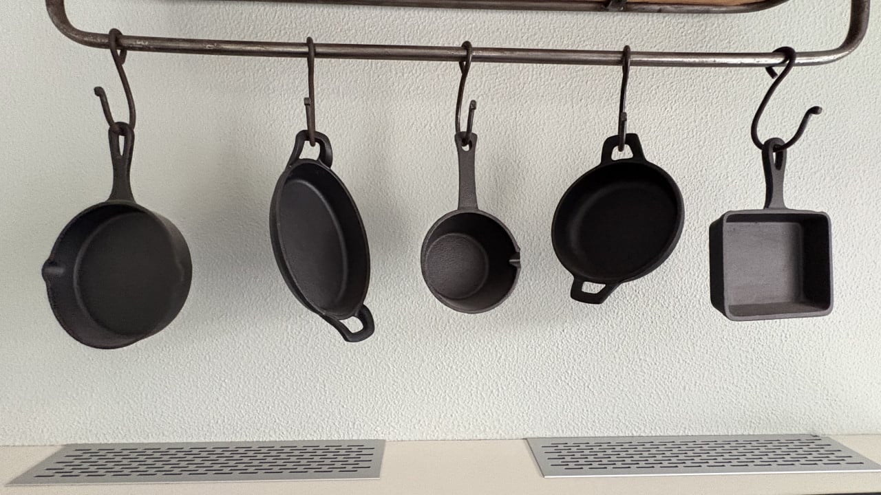 Metalen bakkersrek met gietijzeren pannetjes