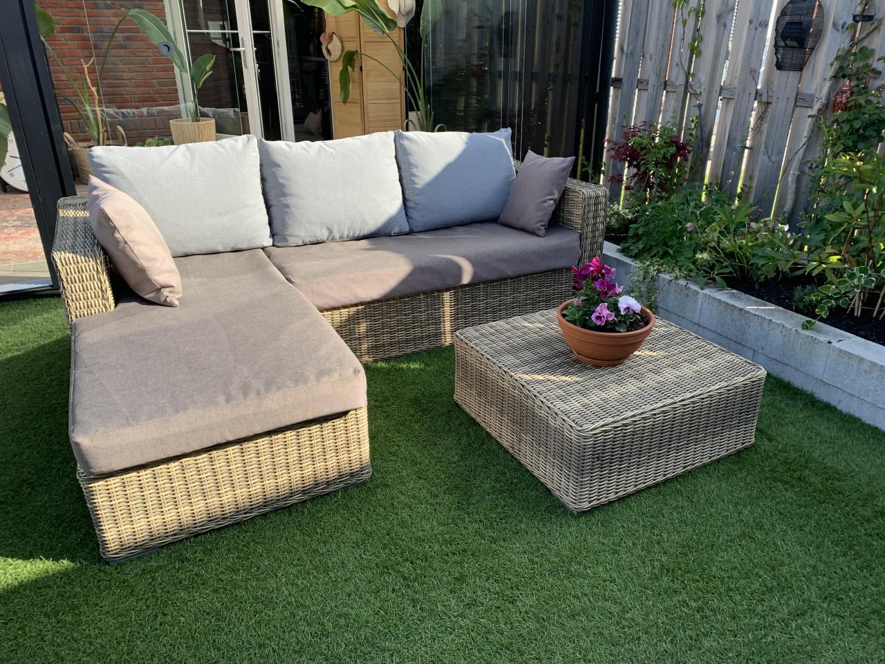 Rieten loungeset, met kussens en tafel.