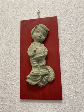 Houten bordje met stenen beeldje erop