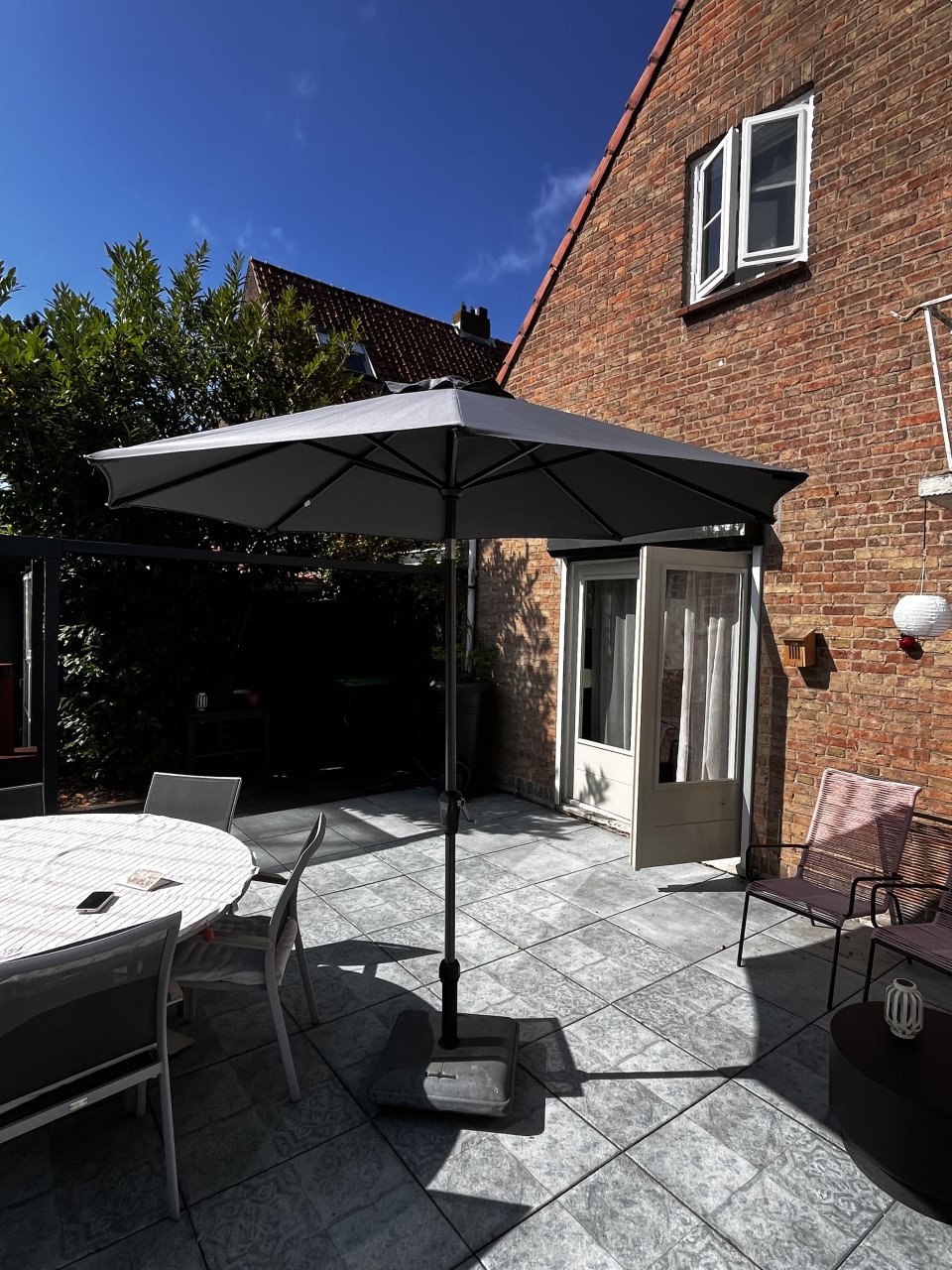 Parasol van Intratuin, met voet en hoes.