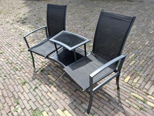 Tuinzitje, twee stoelen verbonden met een tafeltje.