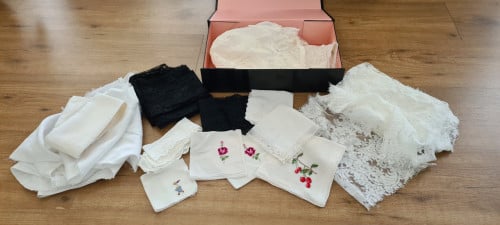 Doos gevuld met wit satijn, kant en antieke zakdoekjes
