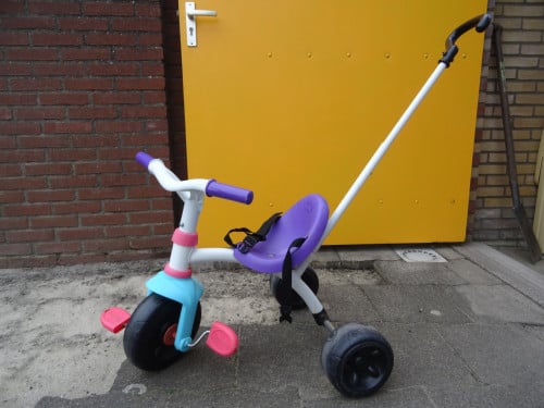 Driewieler met tuigje en in hoogte verstelbare duwstang