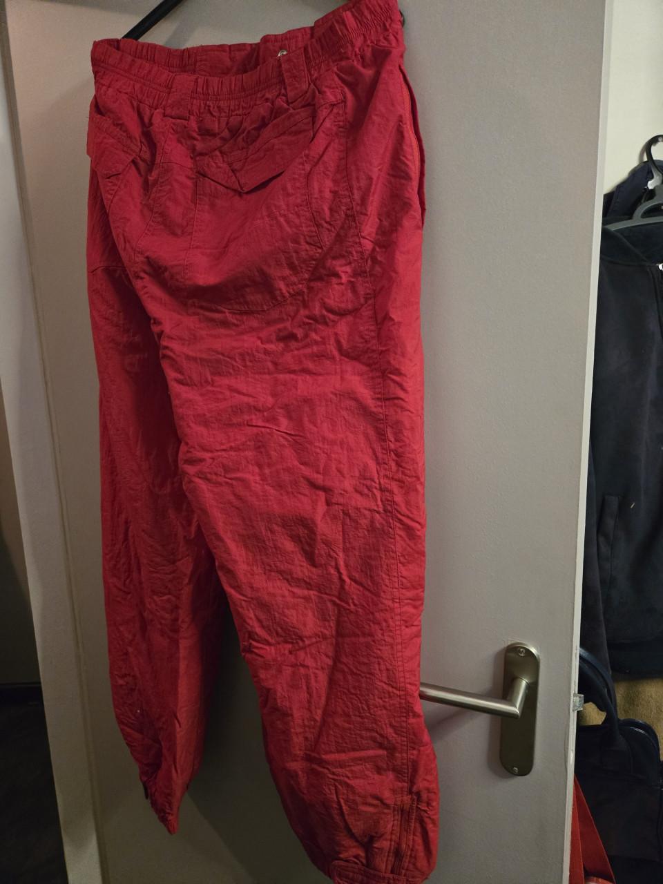 Rode skibroek Maat L  Sluiting met rits en drukker.