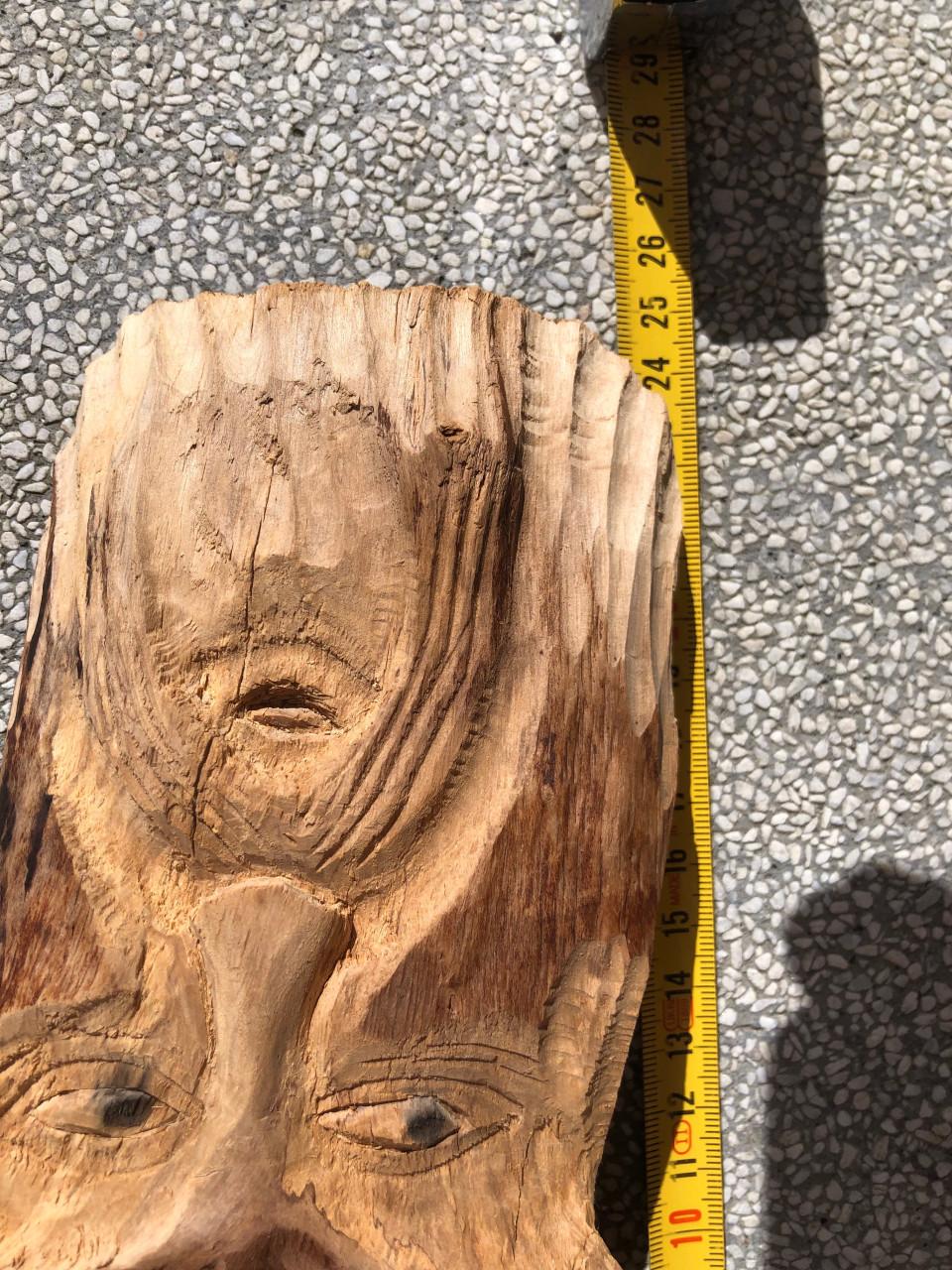 Dit is een houten wanddecoratie in de vorm van een gezicht met baard.