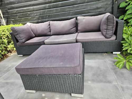 Te koop wicker loungebank met hocker.