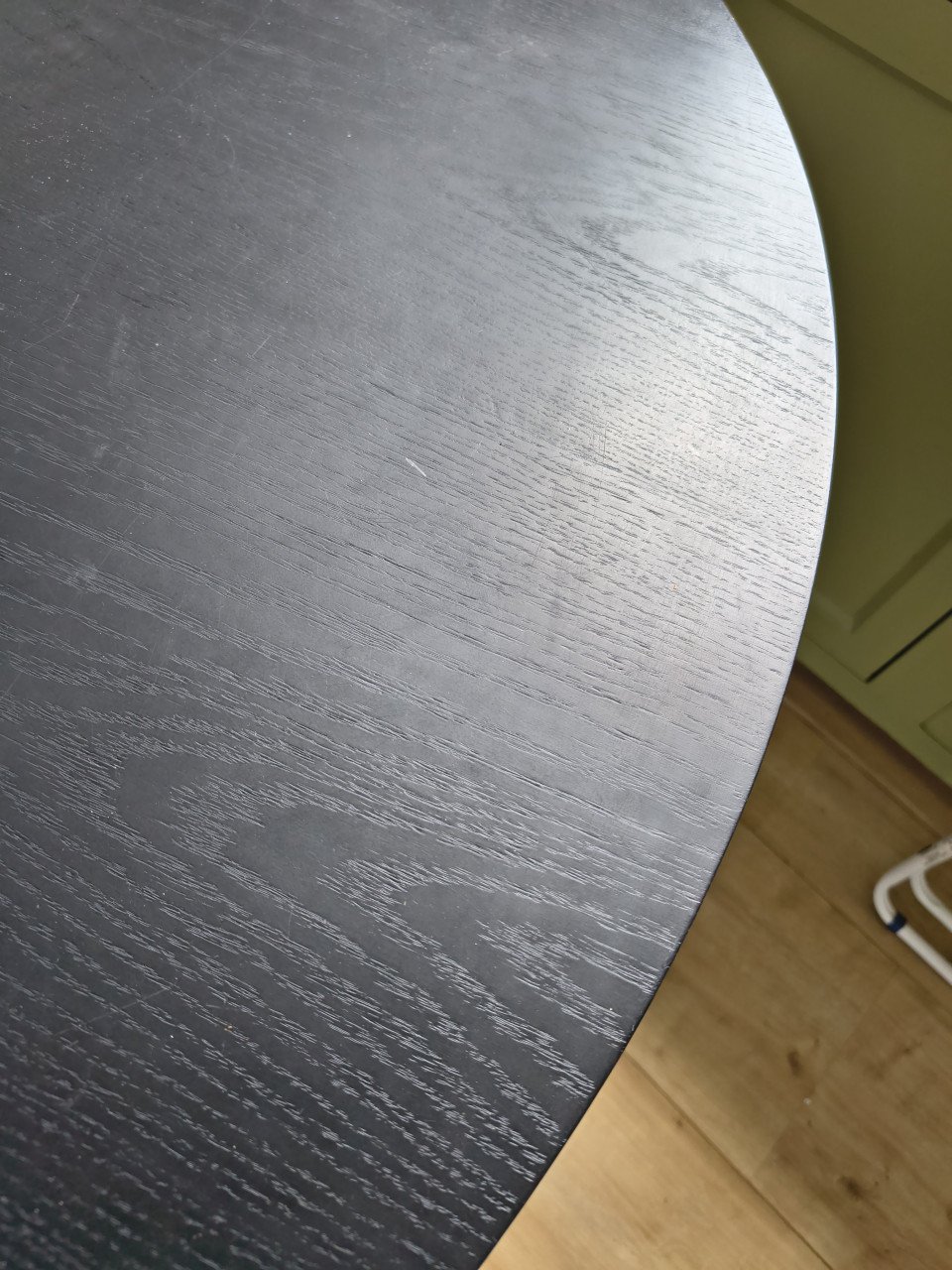 Prachtige ronde houten zwarte eettafel met metalen poten.