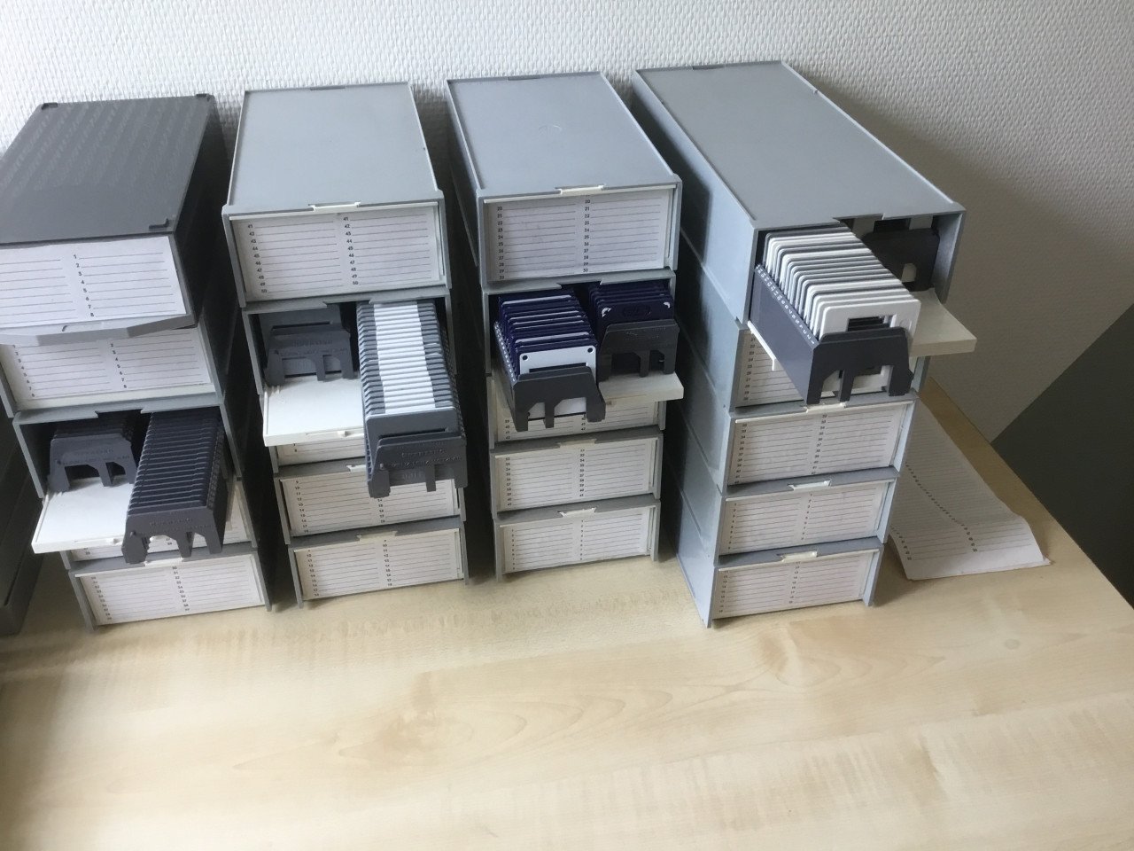 Dia boxen en houders met honderden diaraampjes en dia-viewer.