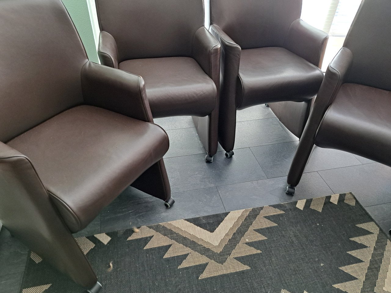 4 bruine kunstlederen stoelen op wieltjes