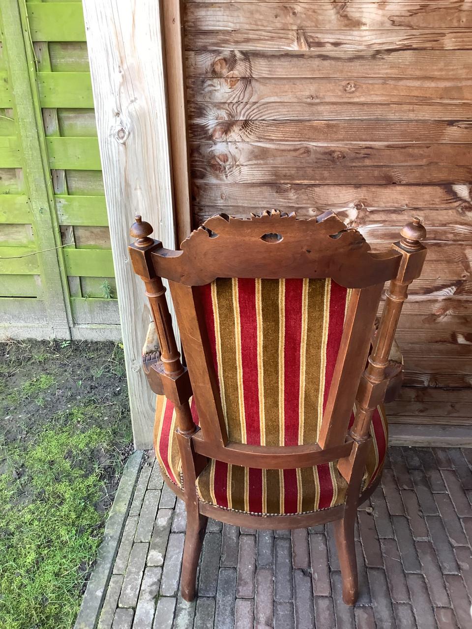 Antieke stoel met gestreepte bekleding.