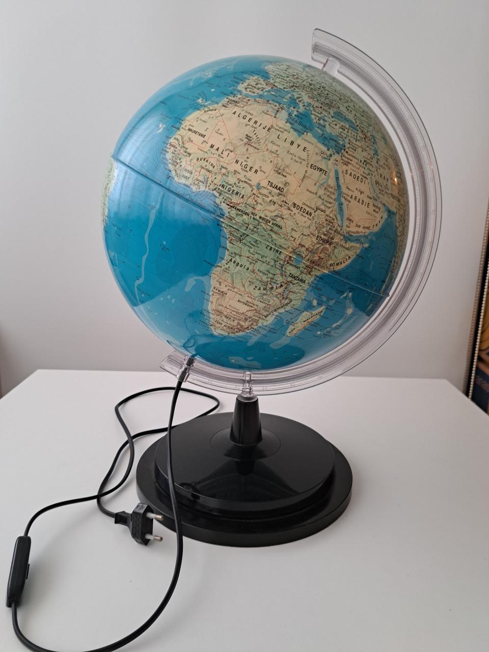 Wereldbol op voet met gradenboog en verlichting