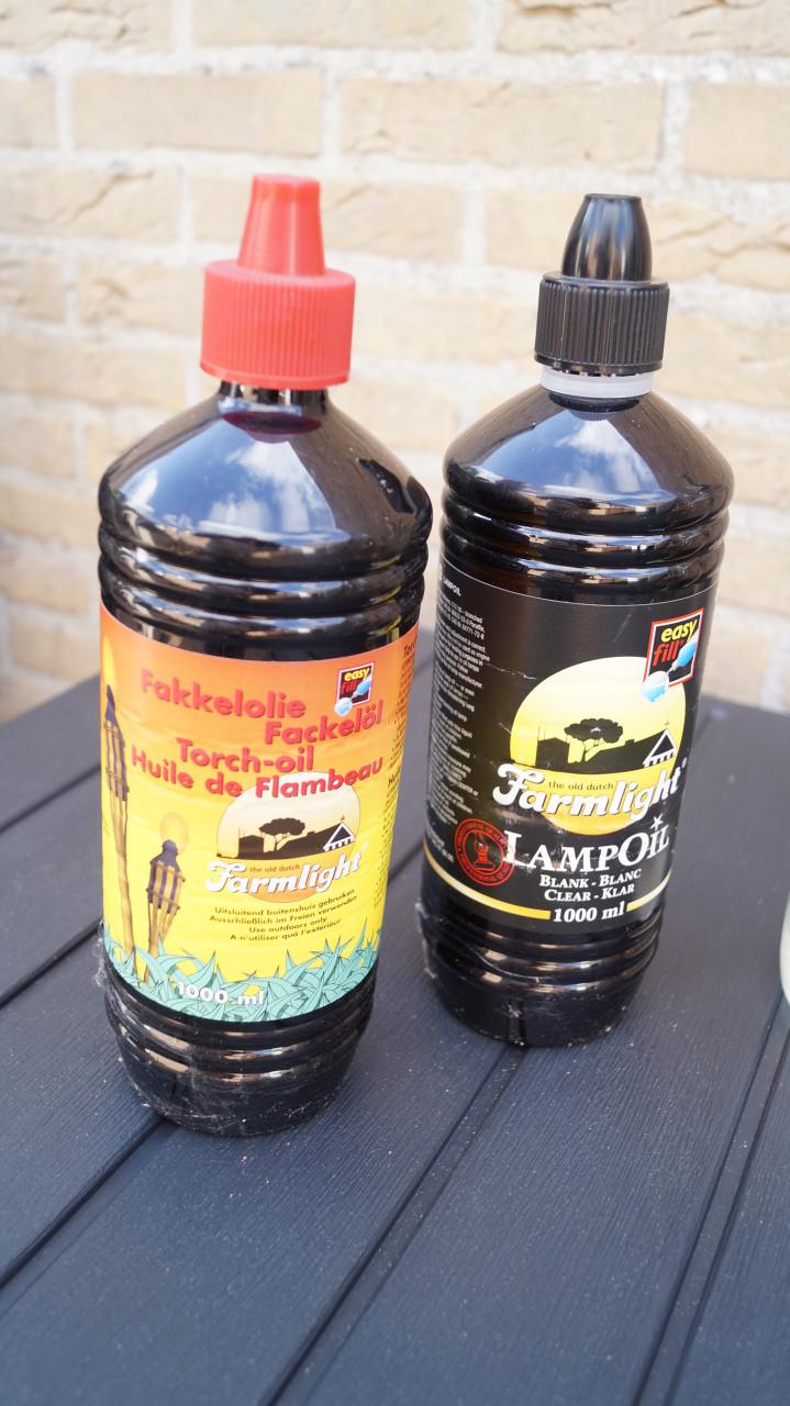 Drie lampolie flessen met lontbranders en gevuld met lampolie