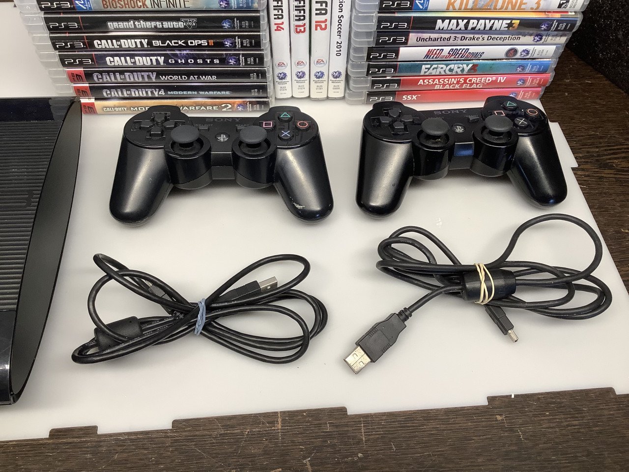 PlayStation 3 slim met 2 controllers en veel spellen.