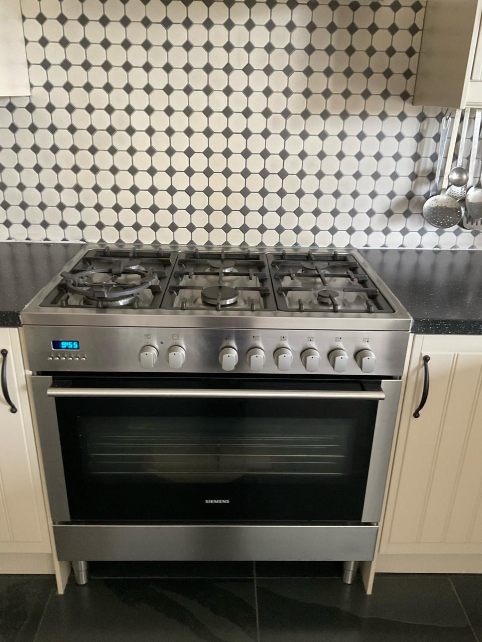 Keuken in U-vorm met 6-pitsgasfornuis, afzuigkap, koelkast en magnetron