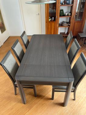Eettafel met verstelbaar blad en zes stoelen.