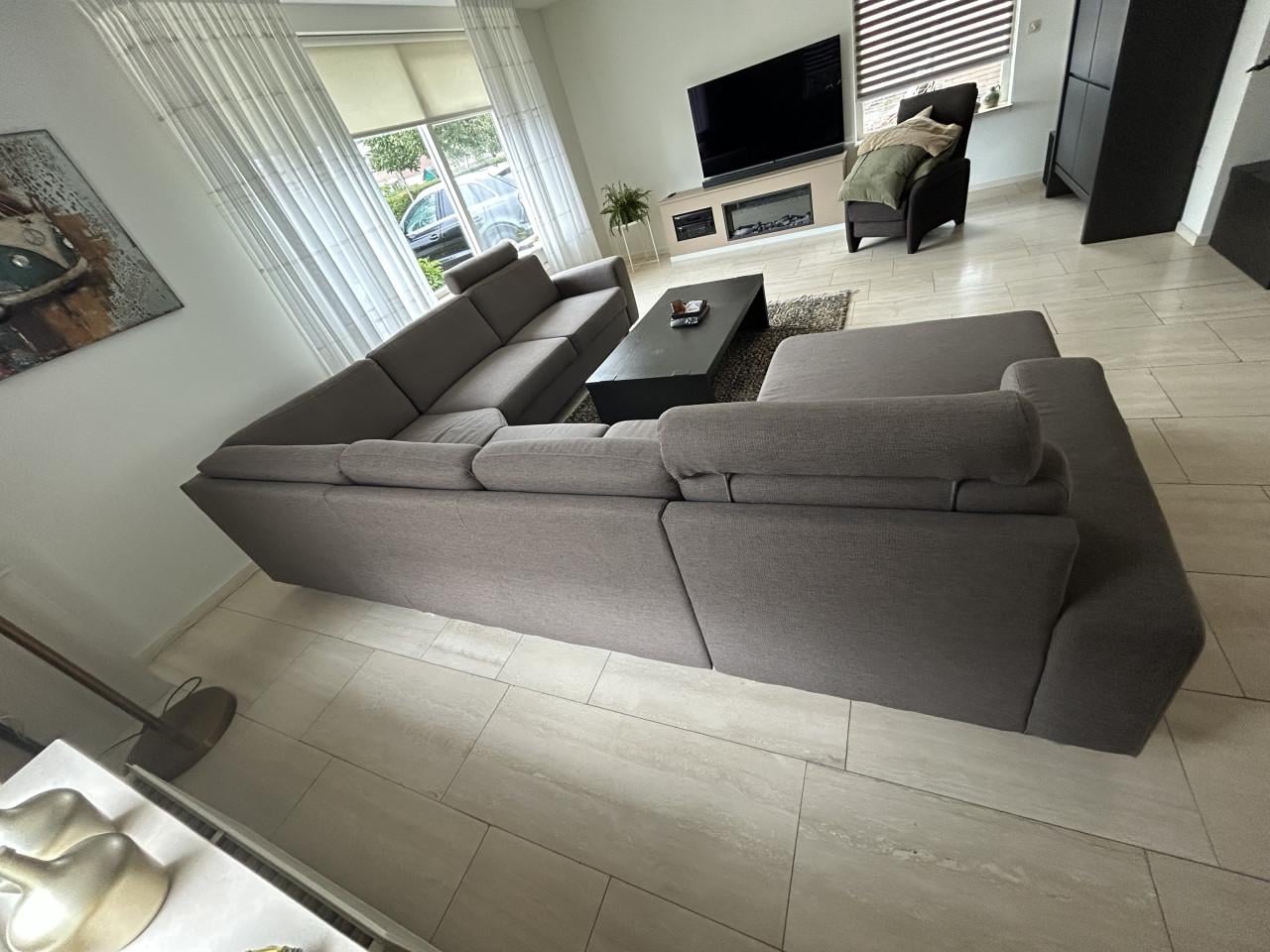 Mooie hoekbank met loungegedeelte en hoofdsteunen in Taupe kleur.