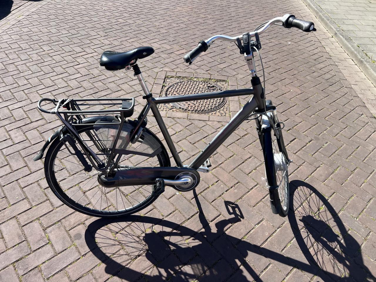 08 Zwart - grijskleurige herenfiets van het merk “ Gazelle ”.
