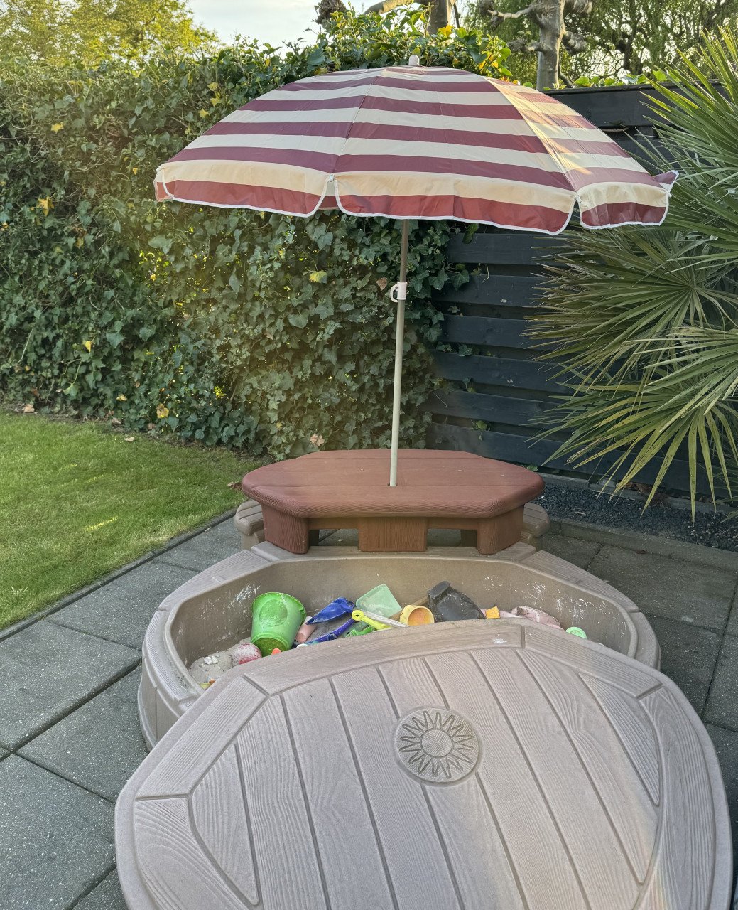 Zandbak met bankje en parasol
