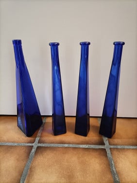 Mooie blauwe flessen, 4 stuks. Driehoekig van vorm. Hoogte 33 cm.