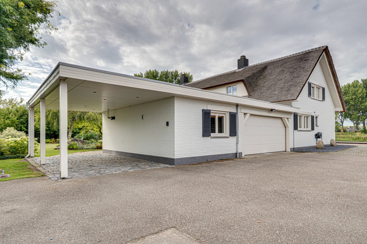 Rietgedekte villa met een overdekt zwembad.