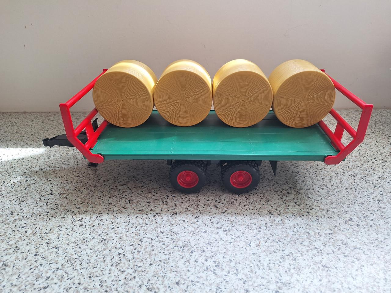 Bruder platte kar met ronde balen.