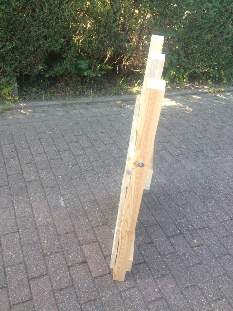 Rechtop hout doorzagen met kettingzaag en compacte zaagbok als werkbank