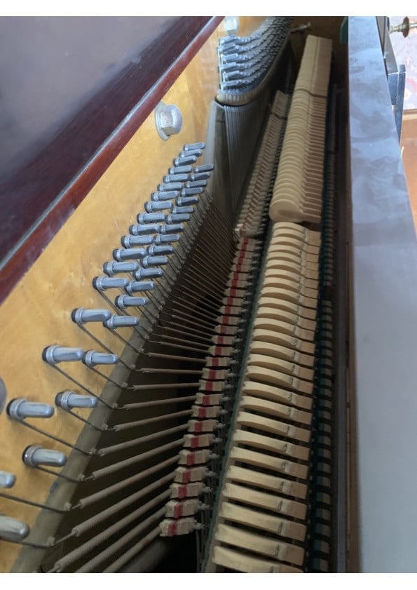 Oude bruine piano met kandelaren