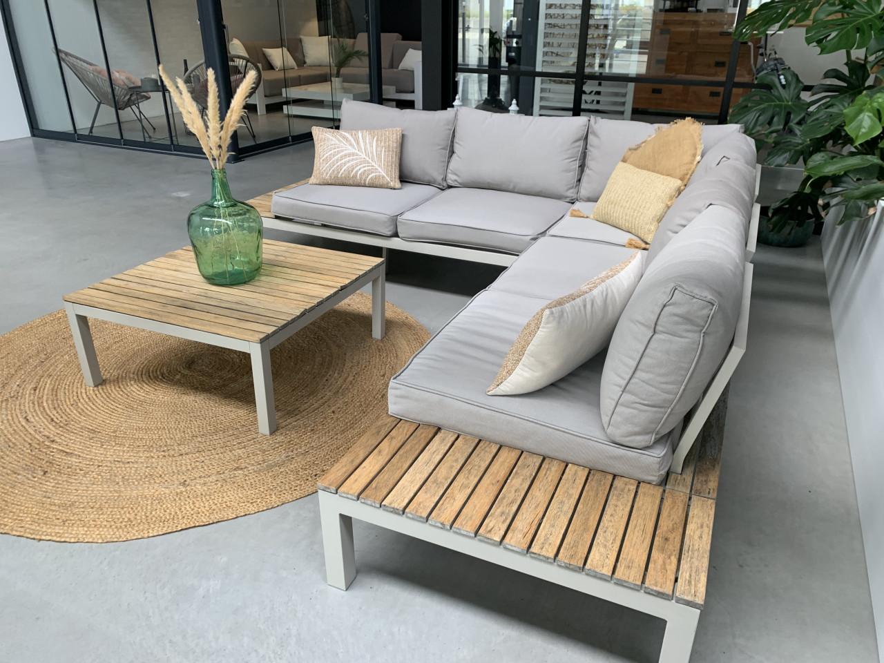 Loungset met houten elementen, kussens en tafel.