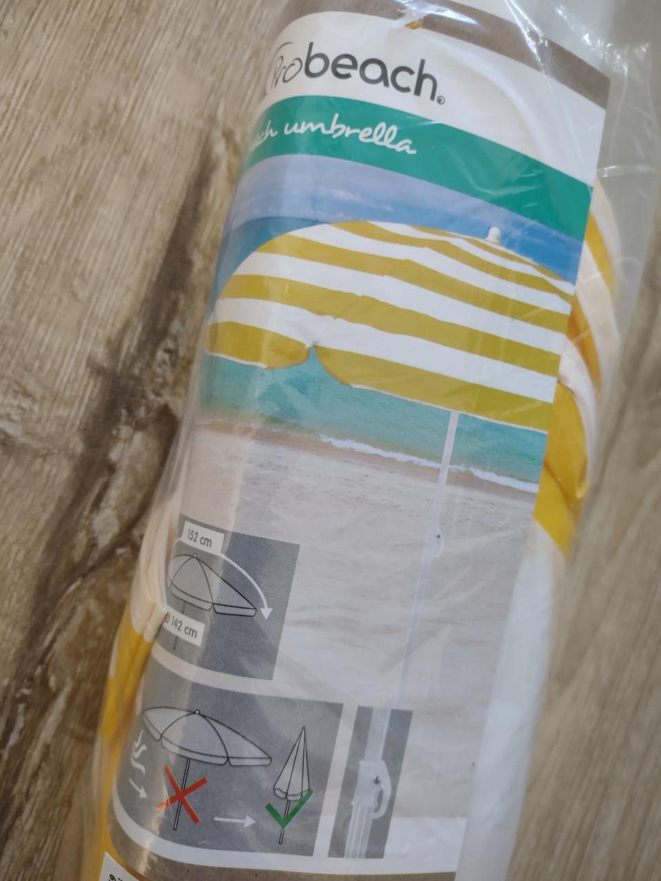 Prachtige nieuwe geel wit gestreepte strandparasol, parasol.