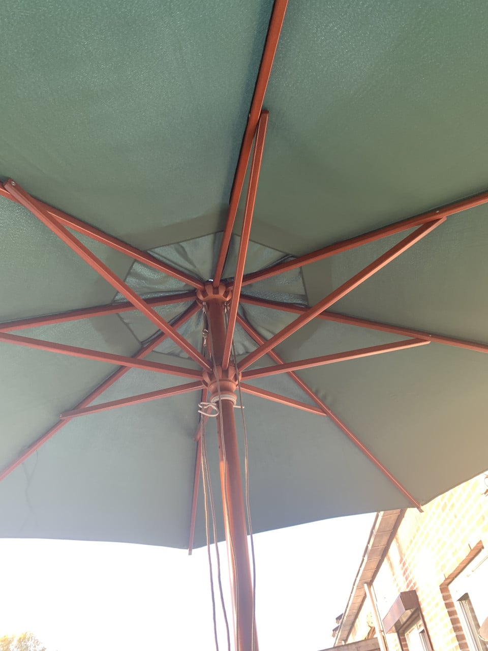 Nieuwe achthoekige stokparasol groene kleur. Met betonnen voet