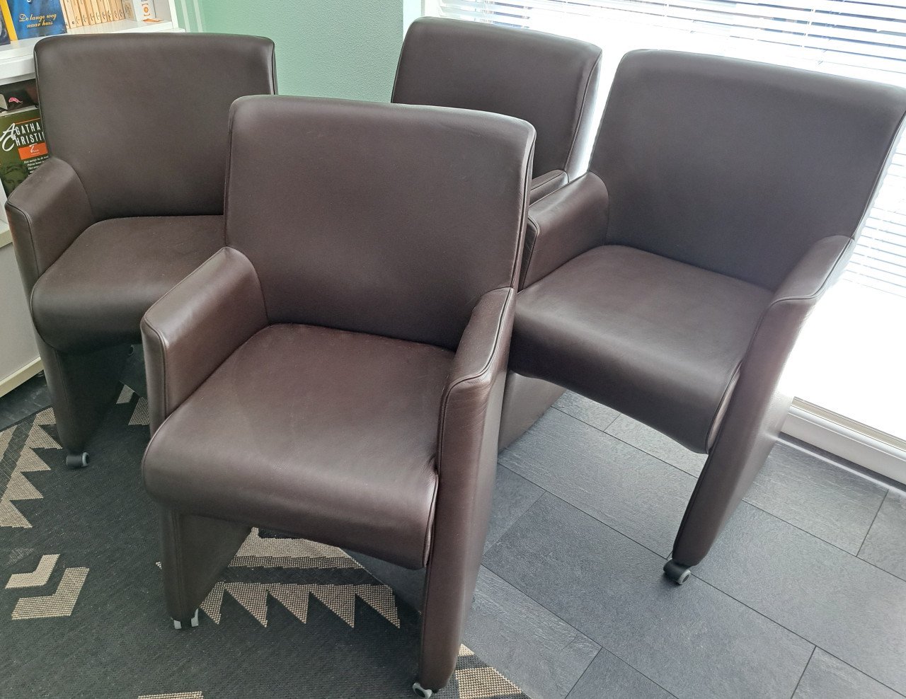 4 bruine kunstlederen stoelen op wieltjes