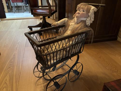 Antieke pop in wandelwagen