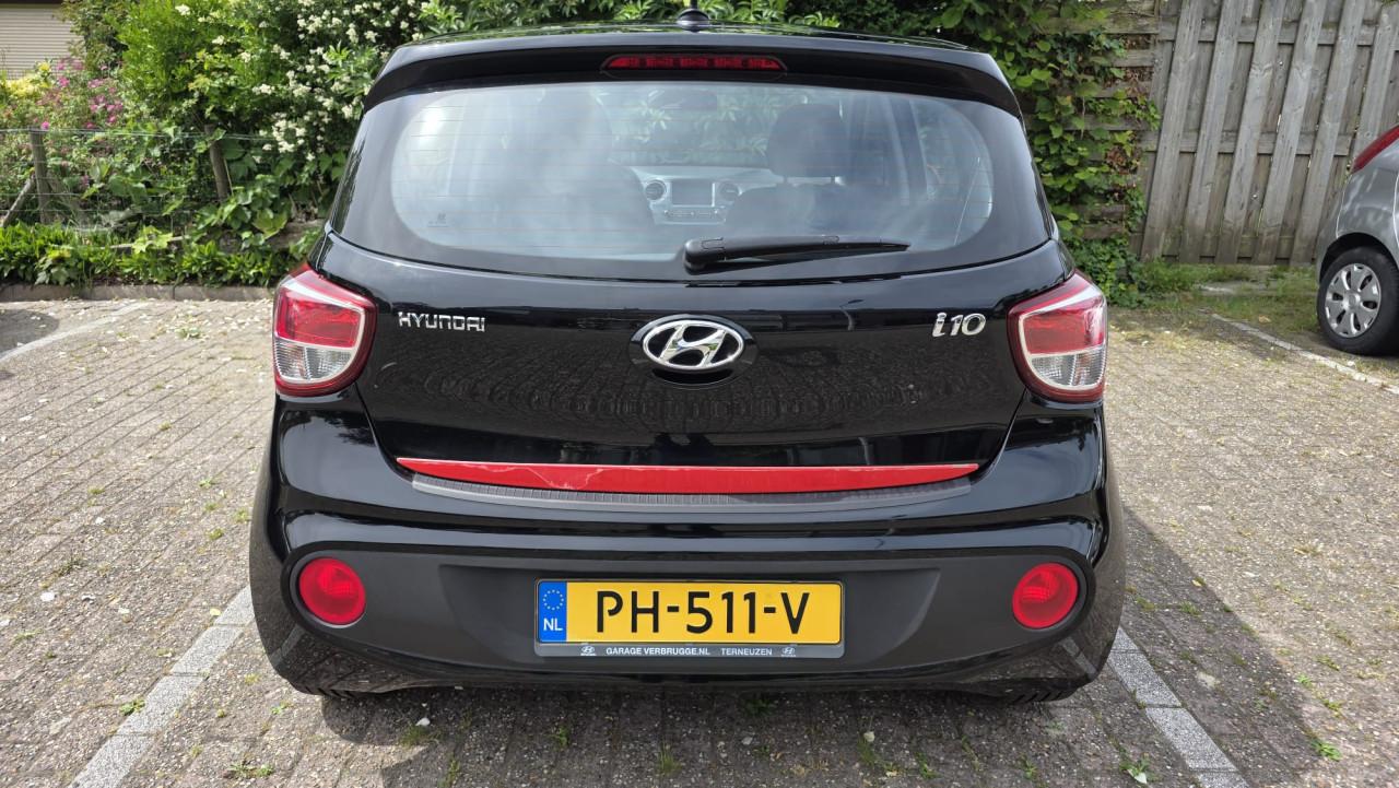 Hyundai I10 2019 met 69300 km Zwart met rode spiegels en sierstrippen.