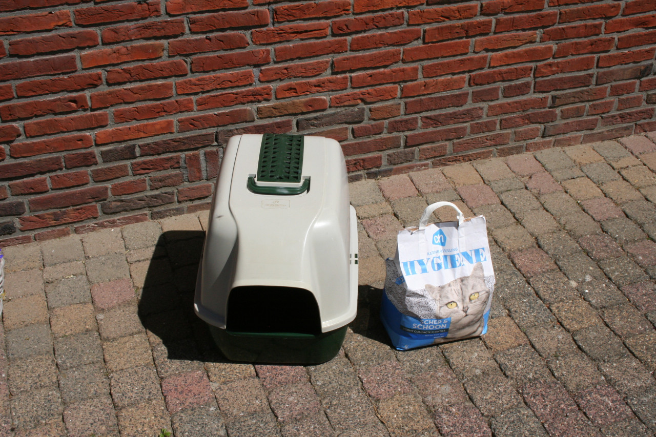 Transportbox en een kattenbak met een zak kattenbakvulling