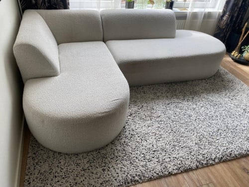 Mooie trendy crèmekleurige hoekbank, teddystof