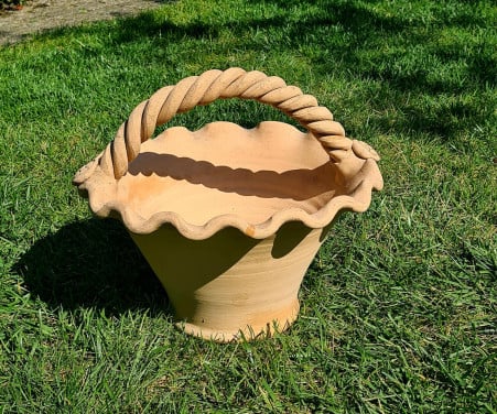 Mooie terracotta bloempot in de vorm van een mand
