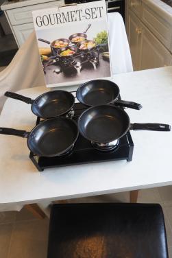Gourmetstel, 1 x gebruikt. Met 4 zwarte pannetjes.