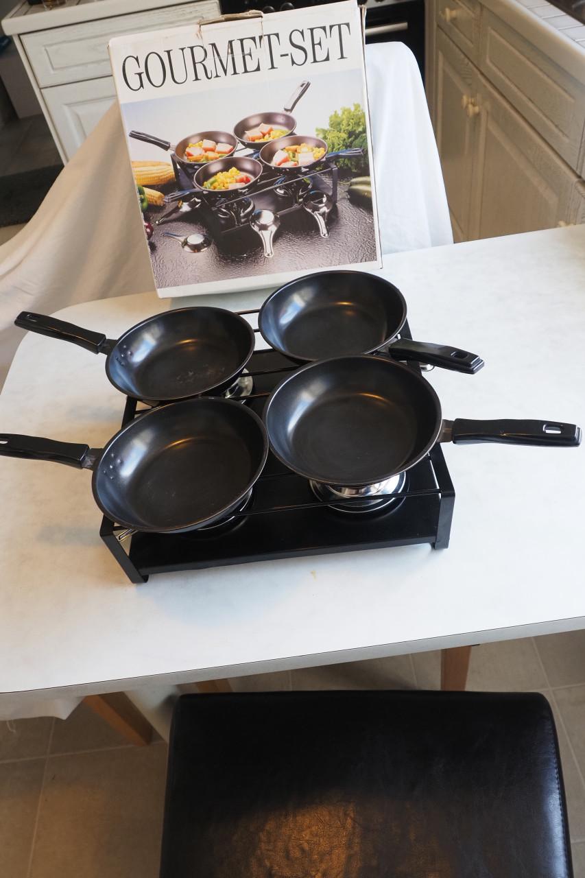 Gourmetstel, 1 x gebruikt. Met 4 zwarte pannetjes.