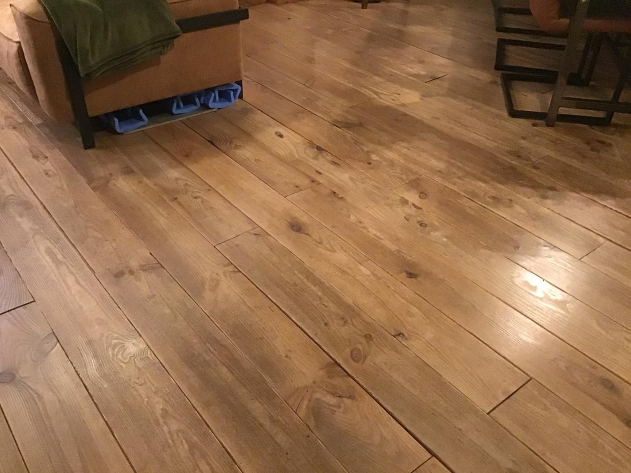 Doorleefde grenen vloer en keuken met koelkast/oven/kookplaat